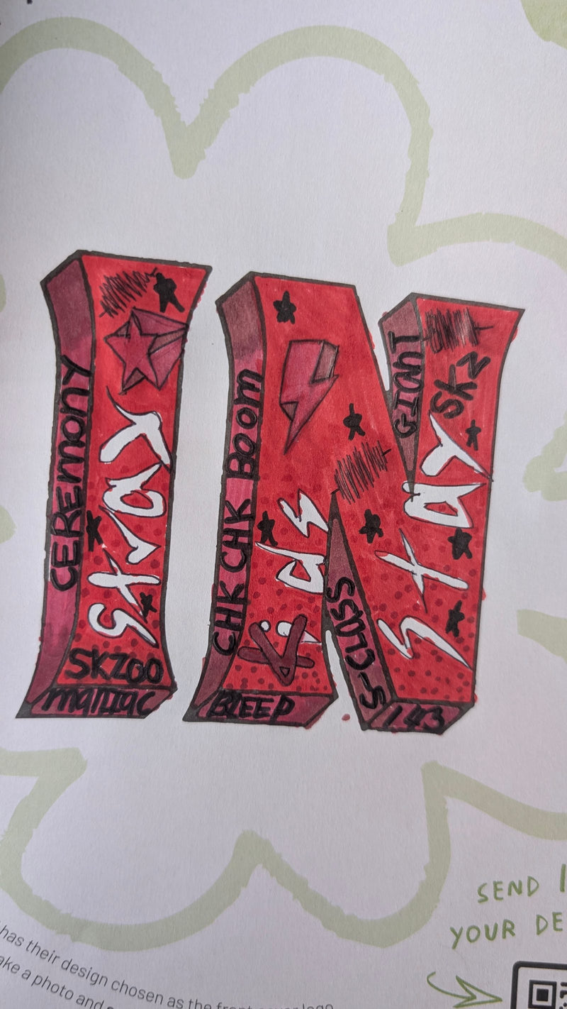 A hand-drawn artwork featuring the letters 'IN' in bold red 3D graffiti-style lettering, decorated with stars, lightning bolts, and various words and phrases written across the surface in black and white.
