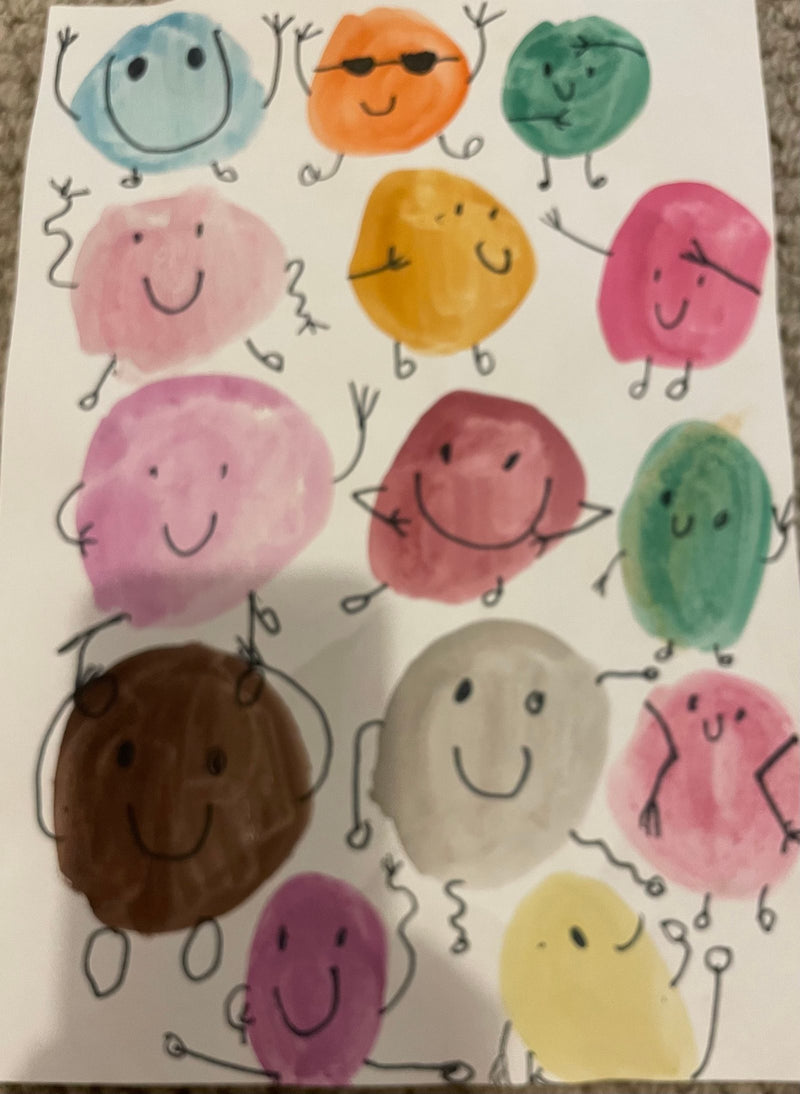 A sheet of paper filled with colourful watercolour blob characters in many different colours including blue, orange, teal, pink, yellow, brown, and purple. Each blob has a cheerful face and stick arms and legs drawn on with black marker, giving them fun personalities.