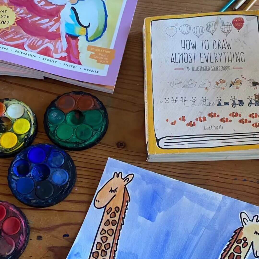 A kid mid-creation with an open spread of theINmag.