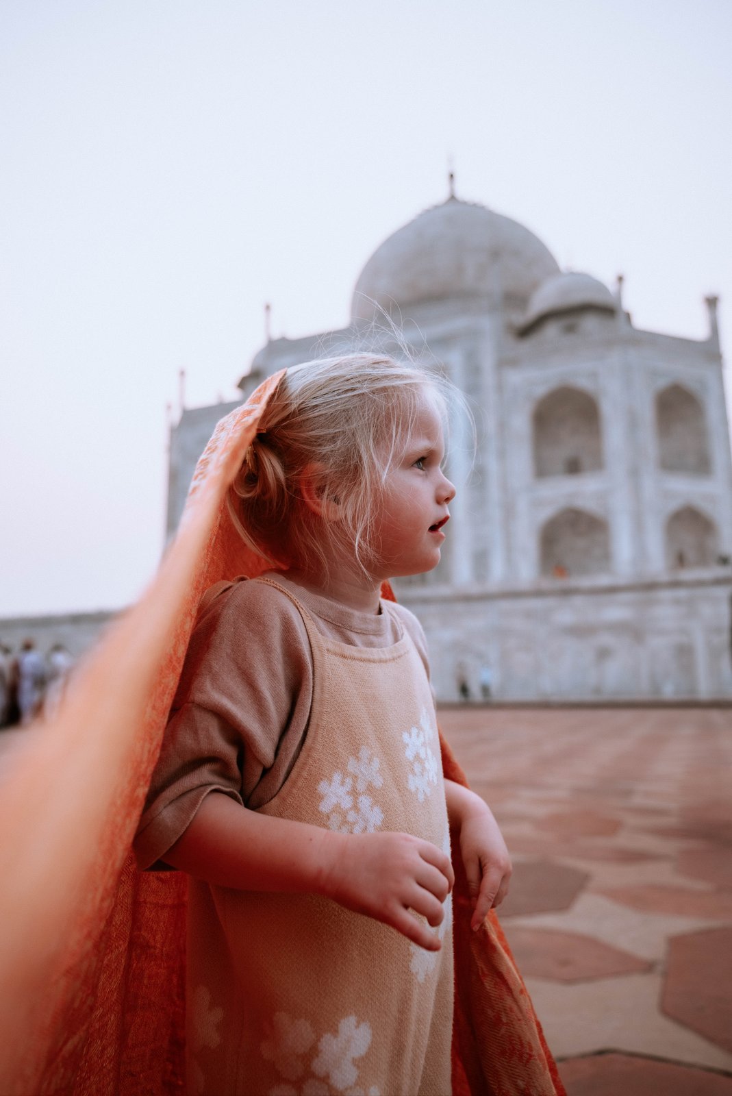 A child stands in front of the Taj Mahal in India.