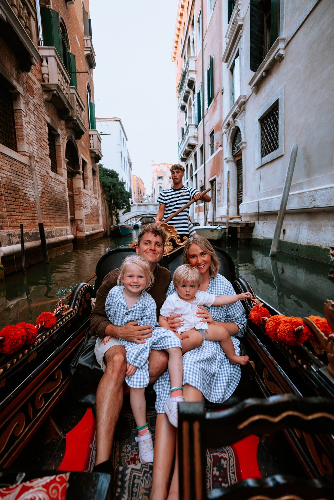The whole family together in a gondola on a Venice canal.